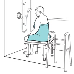 Person sitting on chair, with body turned toward showerhead and walker set away from chair.