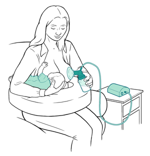 Mother sitting to breastfeed baby on one breast and pump milk on the other breast.